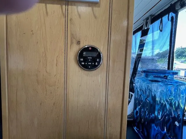 Slide: The Image of Thermostat on wooden wall inside 2001 Horizon 16 x 70 houseboat, with blue container nearby. - 12