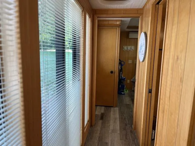 Slide: The Image of Narrow hallway inside a 2001 Horizon 16 x 70 houseboat with wooden paneling and blinds. - 20