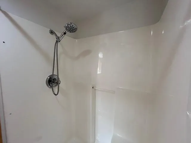 Slide: The Image of Shower area in a 2001 Horizon 16 x 70 houseboat, featuring a modern showerhead. - 22