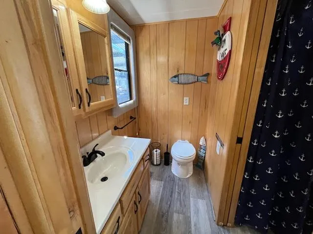 Slide: The Image of Bathroom in 2001 Horizon 16 x 70 houseboat with wood paneling and nautical decor. - 24