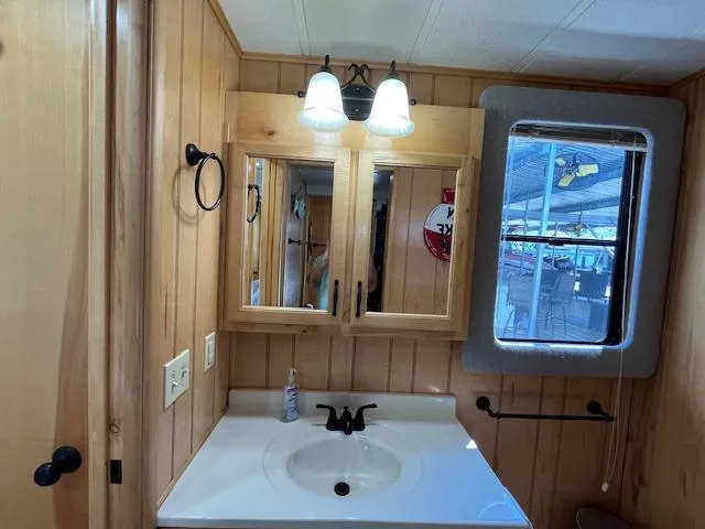 Slide: The Image of Wood-paneled bathroom in 2001 Horizon houseboat with sink, mirror, and window. - 25