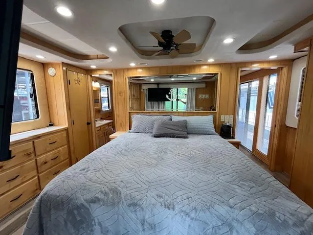 Slide: The Image of Luxurious bedroom interior of 2001 Horizon 16 x 70 houseboat with wood paneling and cozy bedding. - 26