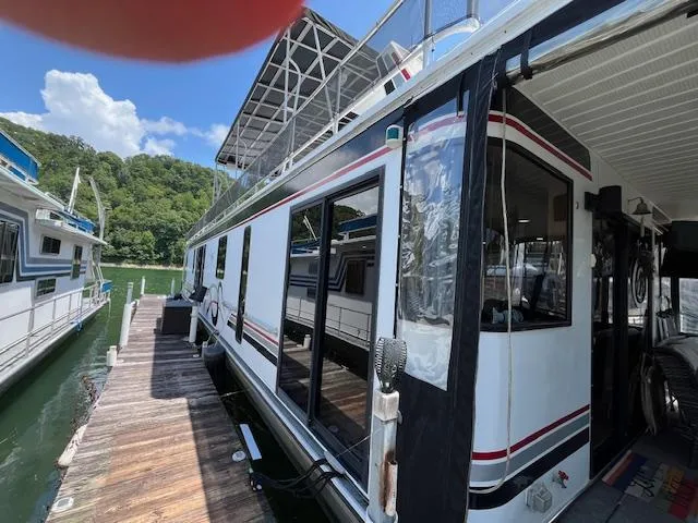 Slide: The Image of 2001 Horizon 16 x 70 houseboat docked, featuring sleek design and spacious deck. - 3