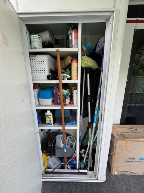 Slide: The Image of Storage closet on a 2001 Horizon 16 x 70 Houseboat, filled with cleaning supplies and tools. - 33