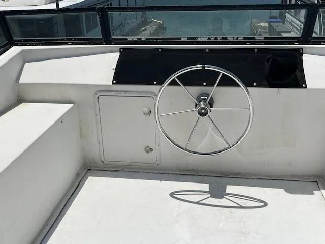 Slide: The Image of Steering wheel of a 2001 Horizon 16 x 70 houseboat, docked with a view of the water. - 36