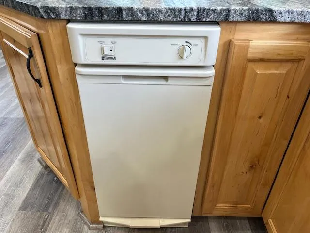 Slide: The Image of Compact white dishwasher in wooden kitchen cabinetry on a 2001 Horizon 16 x 70 Houseboat. - 9