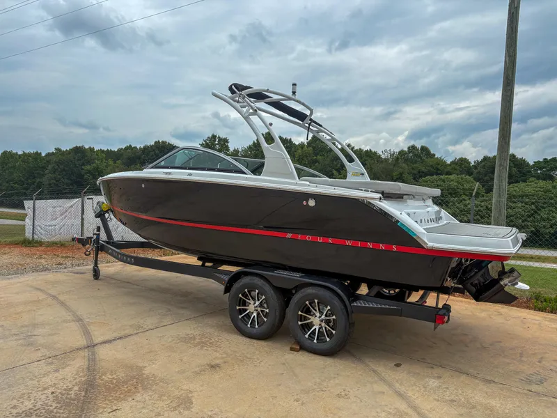The Image of 2026 Four Winns H2 Freedom boat on trailer, parked outdoors under cloudy sky. - 1