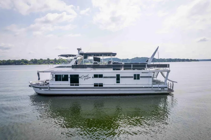 Slide: The Image of 2008 Monticello houseboat on calm lake, featuring spacious upper deck and modern design. - 1