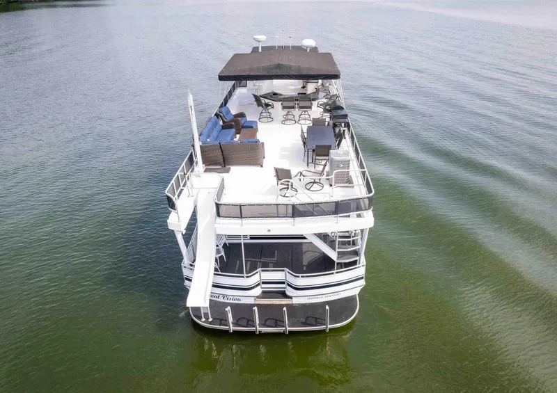 Slide: The Image of 2008 Monticello houseboat on calm water, featuring upper deck seating and slide. - 11