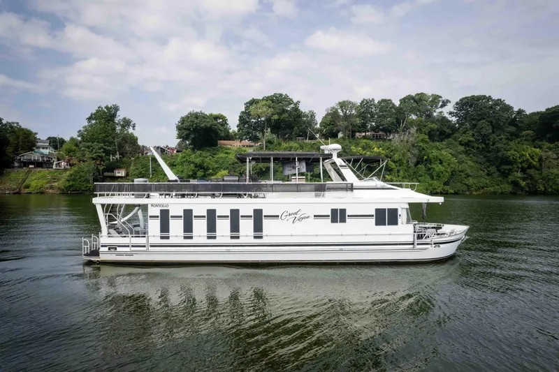 Slide: The Image of 2008 Monticello houseboat cruising on a scenic river with lush green shoreline. - 13