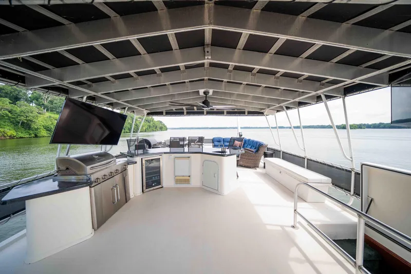 Slide: The Image of Luxurious 2008 Monticello houseboat deck with grill, seating, and scenic lake view. - 16