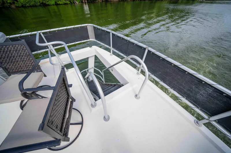 Slide: The Image of 2008 Monticello houseboat deck with chairs, railing, and water view. - 26