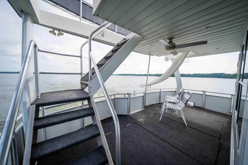 Slide: The Image of 2008 Monticello Houseboat deck with stairs, chairs, and lake view. - 32
