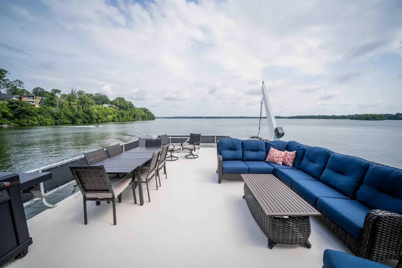 Slide: The Image of Spacious deck of 2008 Monticello houseboat with blue seating, dining area, and scenic lake view. - 36
