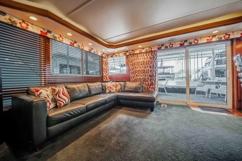 Slide: The Image of Luxurious 2008 Monticello houseboat interior with leather sofa, floral decor, and large windows. - 43