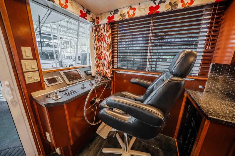 Slide: The Image of 2008 Monticello houseboat helm with leather chair, control panel, and floral curtains. - 46