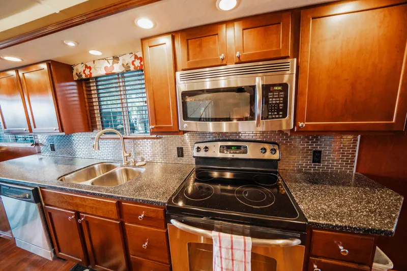 Slide: The Image of Modern kitchen in 2008 Monticello houseboat with stainless steel appliances and wooden cabinets. - 48