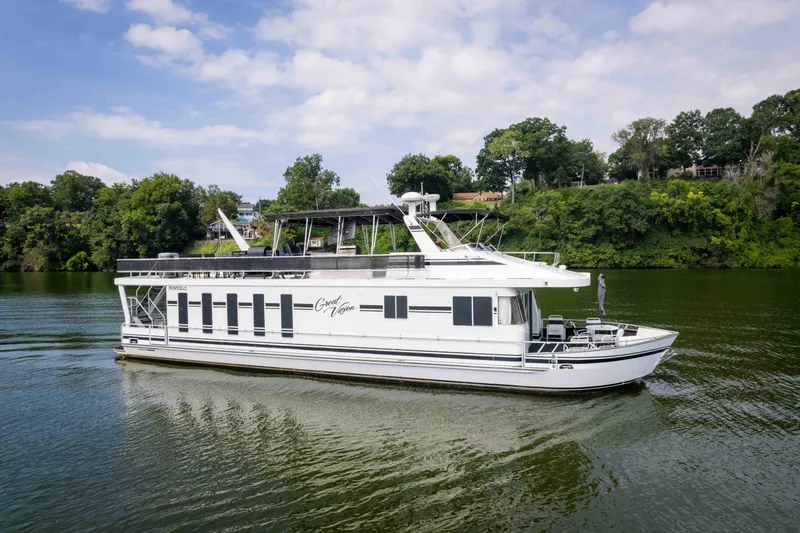 Slide: The Image of 2008 Monticello houseboat on a serene river, surrounded by lush greenery. - 5