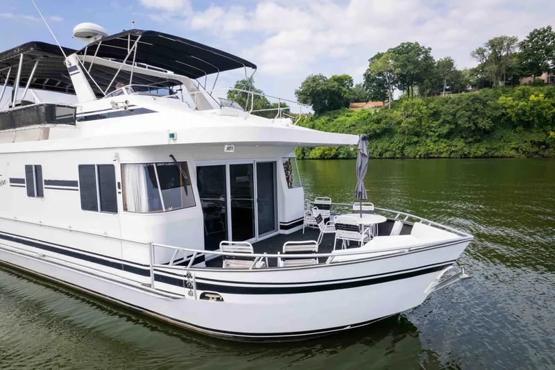 Slide: The Image of 2008 Monticello houseboat on a river, featuring a spacious deck and modern design. - 7