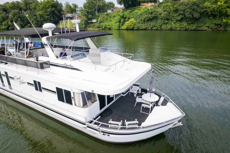 Slide: The Image of 2008 Monticello Houseboat on a serene river, featuring spacious deck and modern amenities. - 8