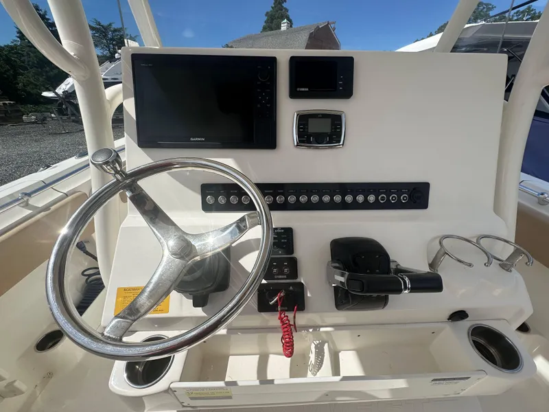 Slide: The Image of 2019 Key West 263 FS boat dashboard with steering wheel, Garmin display, and control panel. - 10