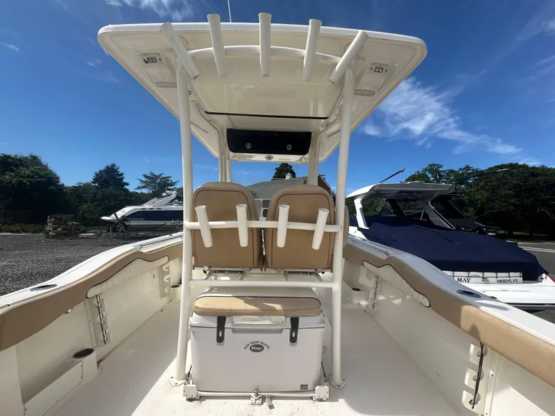 Slide: The Image of 2019 Key West 263 FS boat interior with seating and cooler, under clear blue sky. - 20