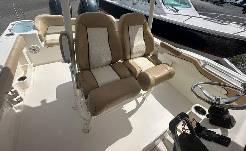 Slide: The Image of 2019 Key West 263 FS boat interior with beige seating and steering wheel. - 8