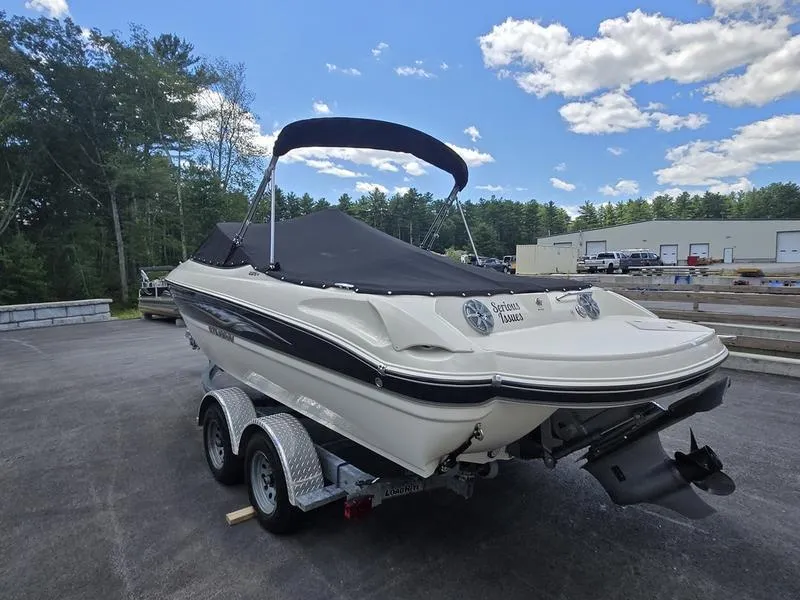 Slide: The Image of 2016 Stingray 225RX boat on trailer, covered, parked outdoors under blue sky. - 17