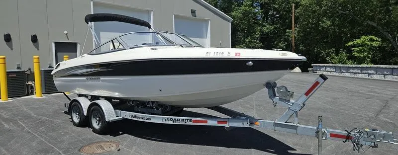 Slide: The Image of 2016 Stingray 225RX boat on trailer, parked outdoors near a building. - 5
