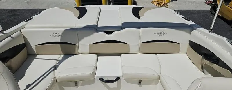 Slide: The Image of 2016 Stingray 225RX boat interior with white and beige seating, featuring logo details. - 7