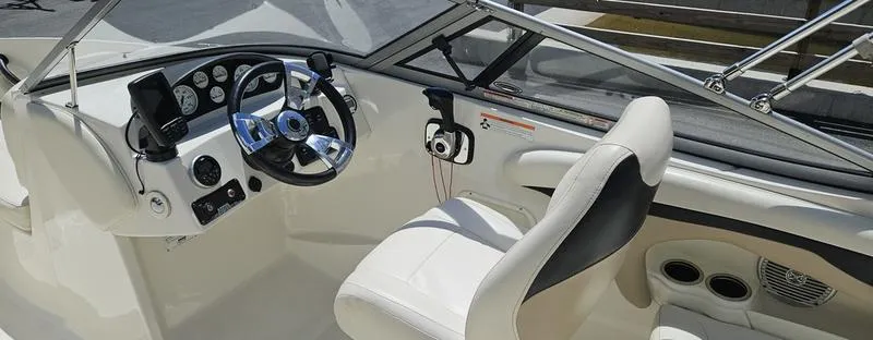 Slide: The Image of Interior of a 2016 Stingray 225RX boat, featuring a sleek steering wheel and comfortable seating. - 9