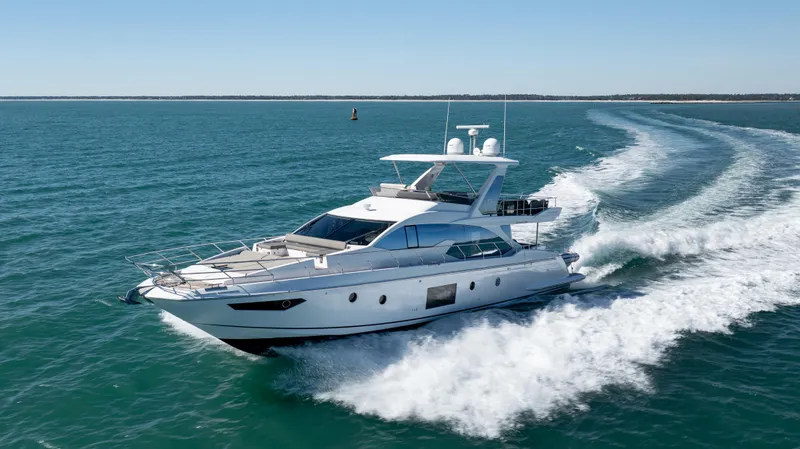 Slide: The Image of 2019 Azimut 66 FLY yacht cruising on open water, creating a wake. - 13
