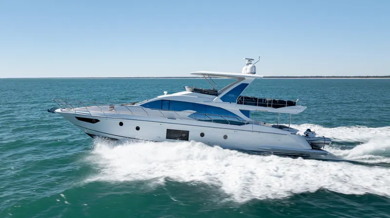 Slide: The Image of 2019 Azimut 66 FLY yacht cruising on open sea under clear blue sky. - 15