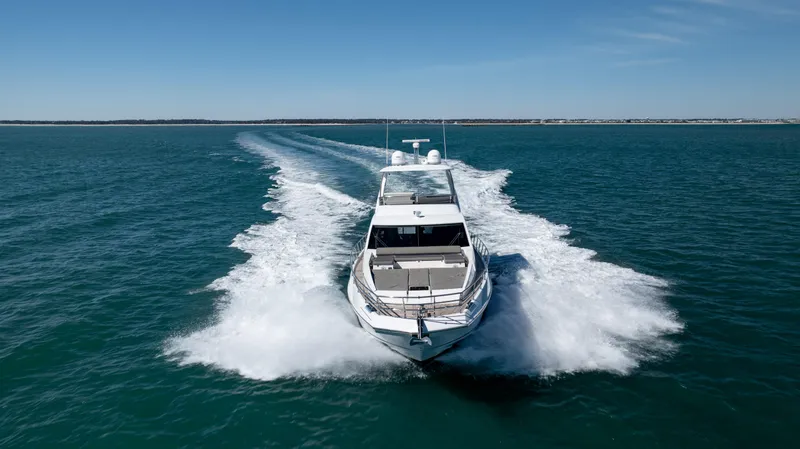 Slide: The Image of 2019 Azimut 66 FLY yacht cruising on open water, leaving a wake behind. - 16