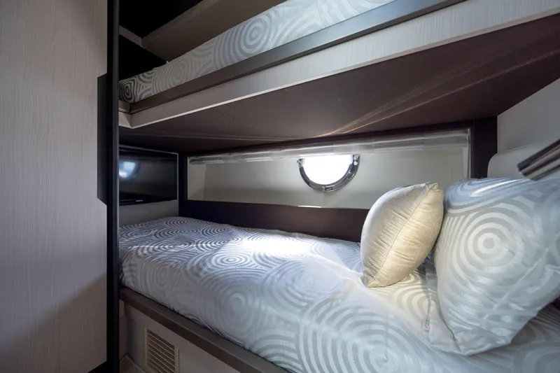 Slide: The Image of Bunk beds in 2019 Azimut 66 FLY yacht cabin with circular window and patterned bedding. - 29