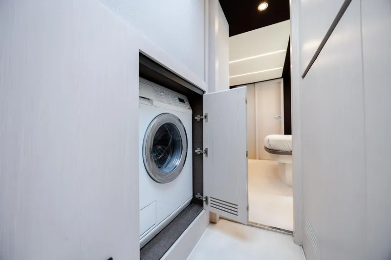 Slide: The Image of Laundry area inside 2019 Azimut 66 FLY yacht, featuring a built-in washing machine. - 31