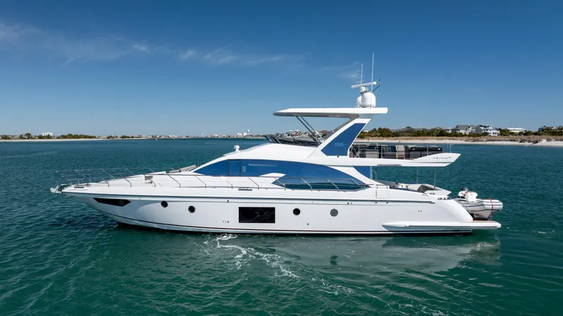 Slide: The Image of 2019 Azimut 66 FLY yacht cruising on clear blue water under a sunny sky. - 4