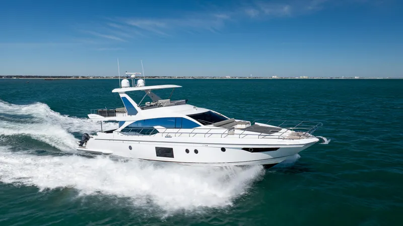 Slide: The Image of Luxurious 2019 Azimut 66 FLY yacht cruising on open water under clear blue skies. - 7