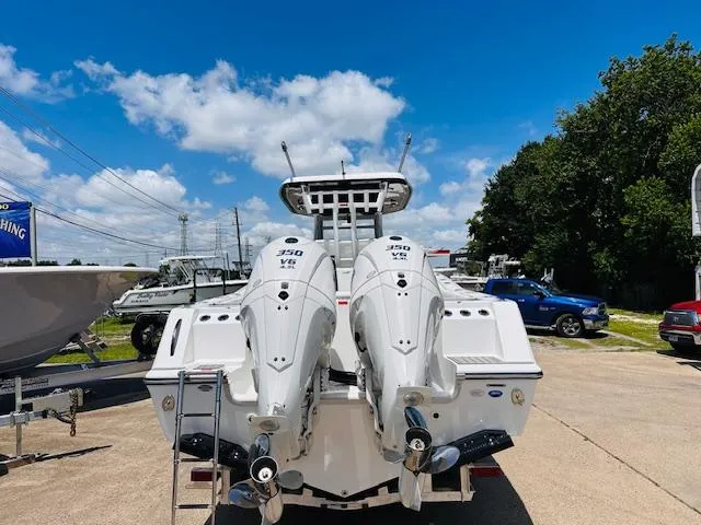 Slide: The Image of 2026 Tidewater 302 CC Adventure boat with twin 350 VR engines, parked outdoors. - 2