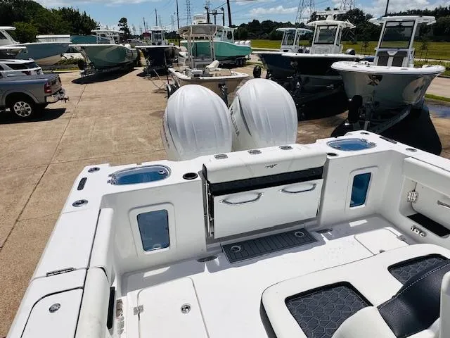 Slide: The Image of 2026 Tidewater 302 CC Adventure boat with dual engines, docked among other boats. - 5