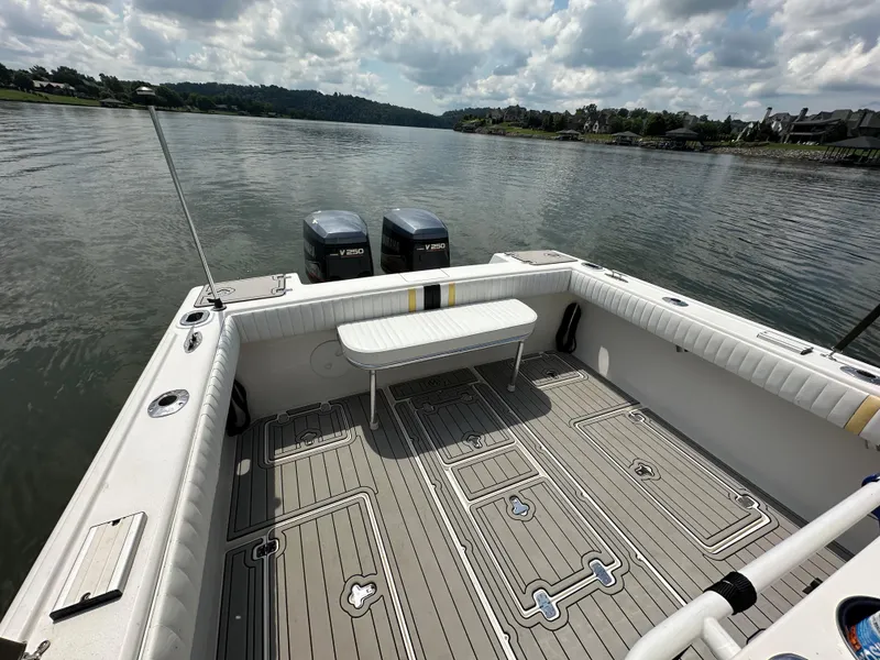 Slide: The Image of 2002 Intrepid 323 Cuddy boat deck with twin V250 engines on a calm lake. - 10