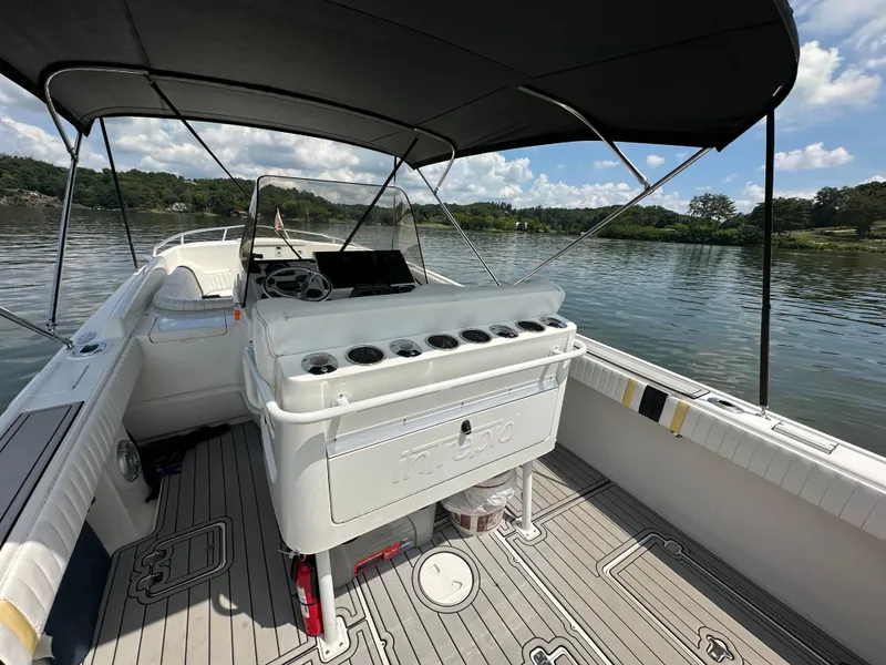 Slide: The Image of 2002 Intrepid 323 Cuddy boat interior with canopy on a calm lake. - 11