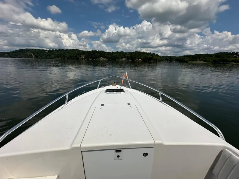 Slide: The Image of Bow view of 2002 Intrepid 323 Cuddy on calm lake under cloudy sky. - 18
