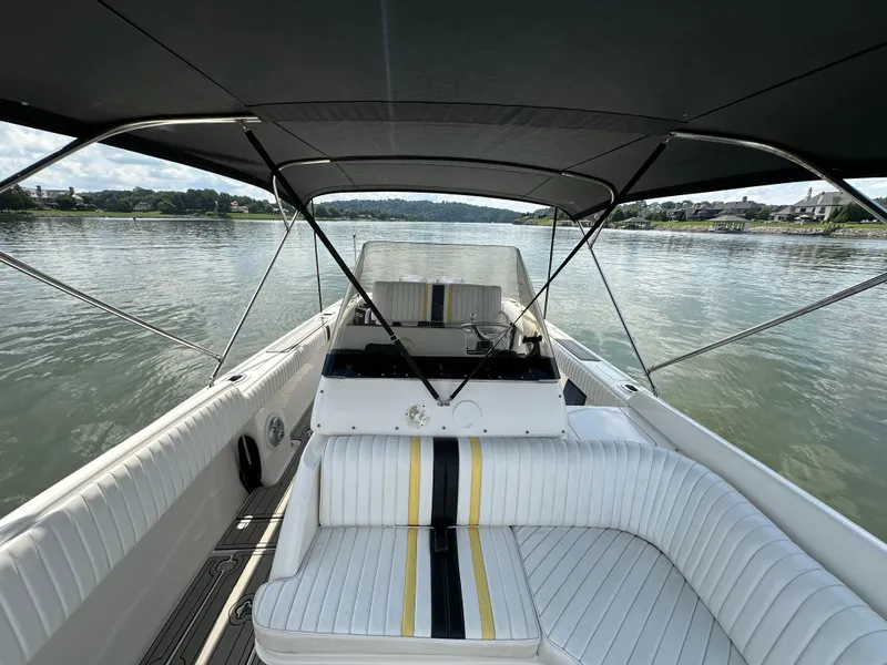 Slide: The Image of 2002 Intrepid 323 Cuddy boat interior with seating, canopy, and scenic water view. - 19