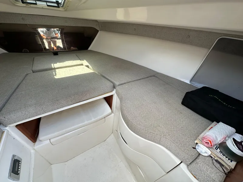 Slide: The Image of 2002 Intrepid 323 Cuddy cabin interior with gray cushions and storage space. - 20