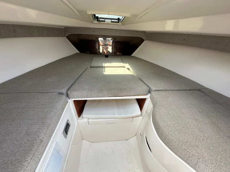 Slide: The Image of Interior of a 2002 Intrepid 323 Cuddy boat with cushioned seating and storage. - 21