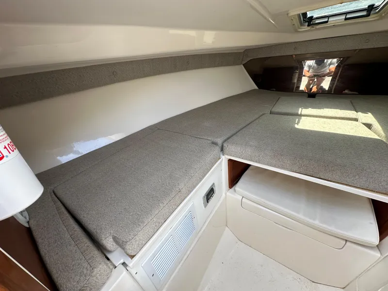 Slide: The Image of Interior of 2002 Intrepid 323 Cuddy boat with cushioned seating and storage. - 22