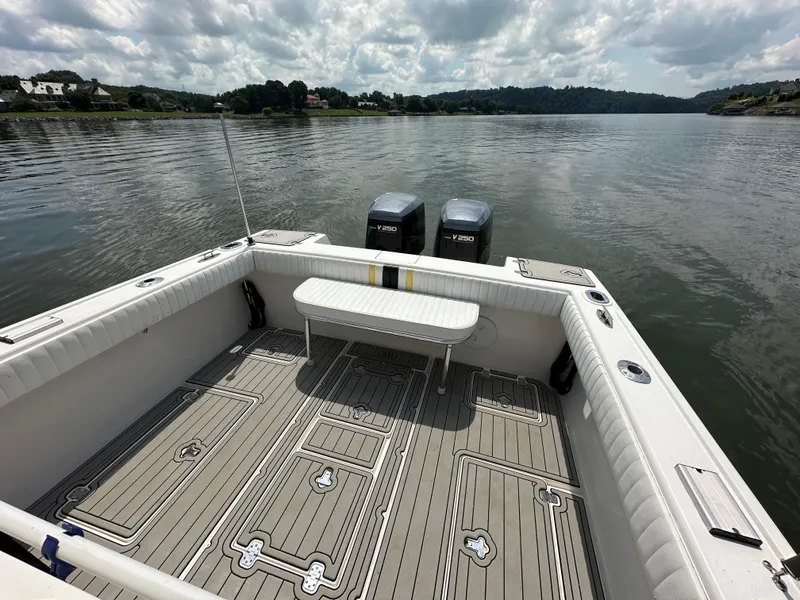 Slide: The Image of 2002 Intrepid 323 Cuddy boat with twin engines on a calm lake. - 9