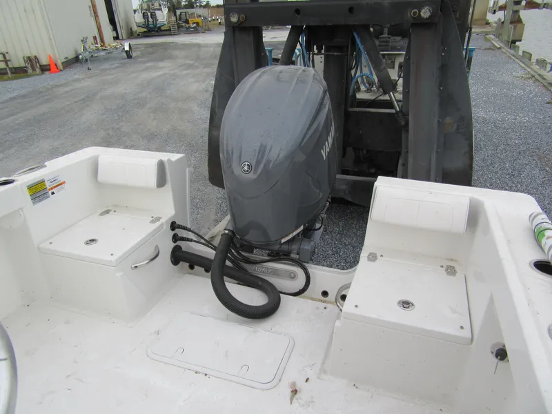 Slide: The Image of 2025 Parker 23SE Center Console boat with Yamaha outboard motor, docked on gravel surface. - 13