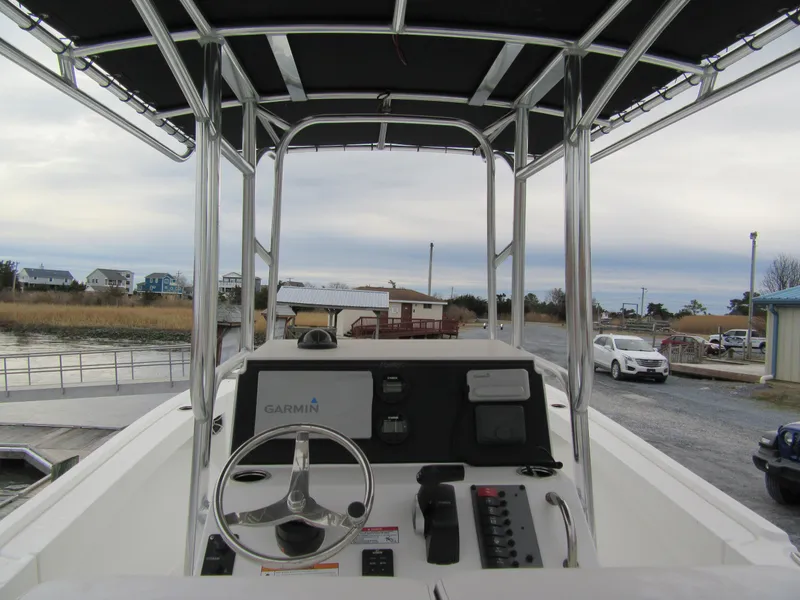 Slide: The Image of 2025 Parker 23SE Center Console boat with Garmin navigation, docked near waterfront homes. - 5